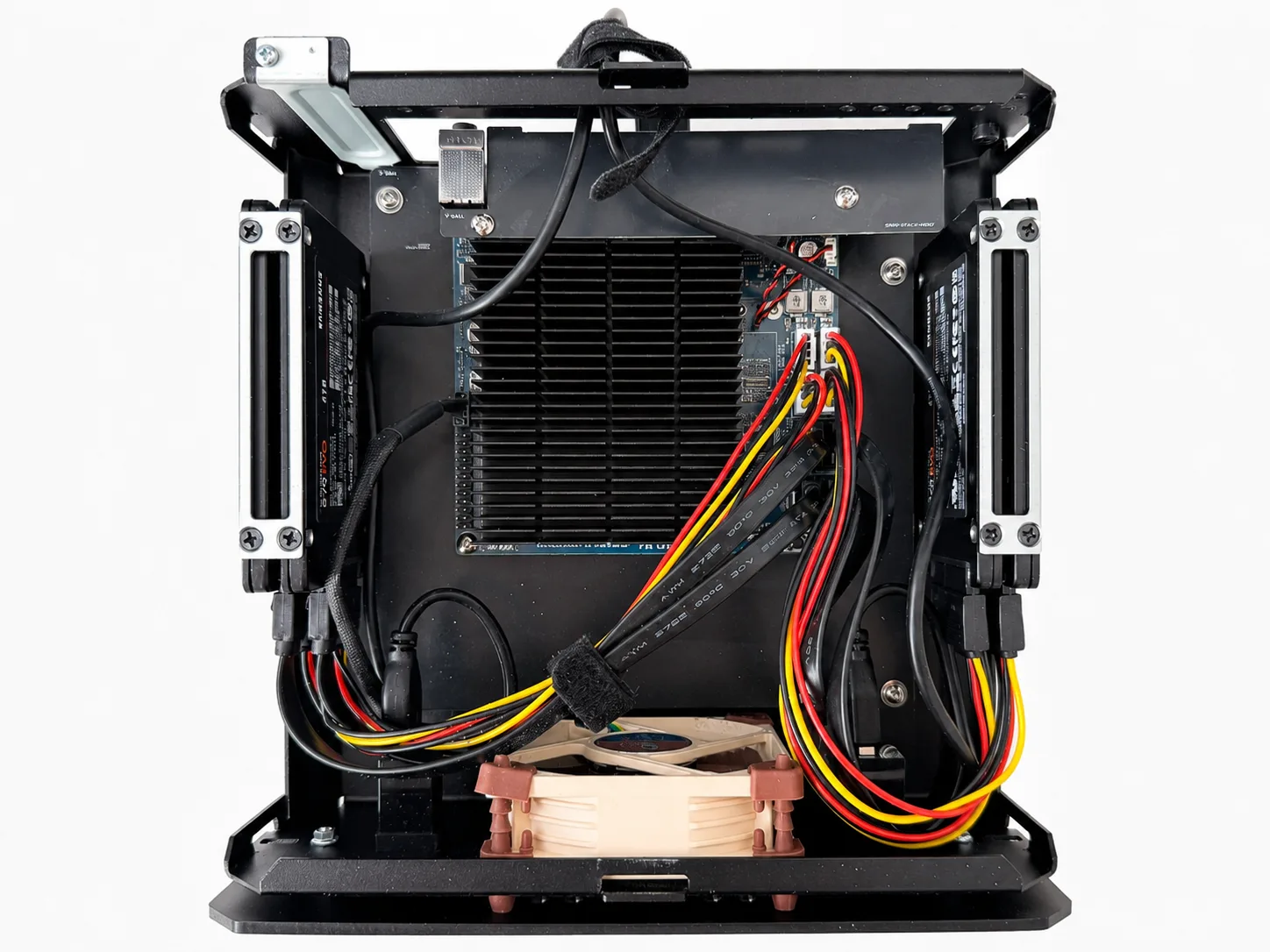 Top-down internal view of the ODROID H4 Ultra NAS build showing the board, heatsink, fan, cabling, and four 2.5-inch SSD positions.